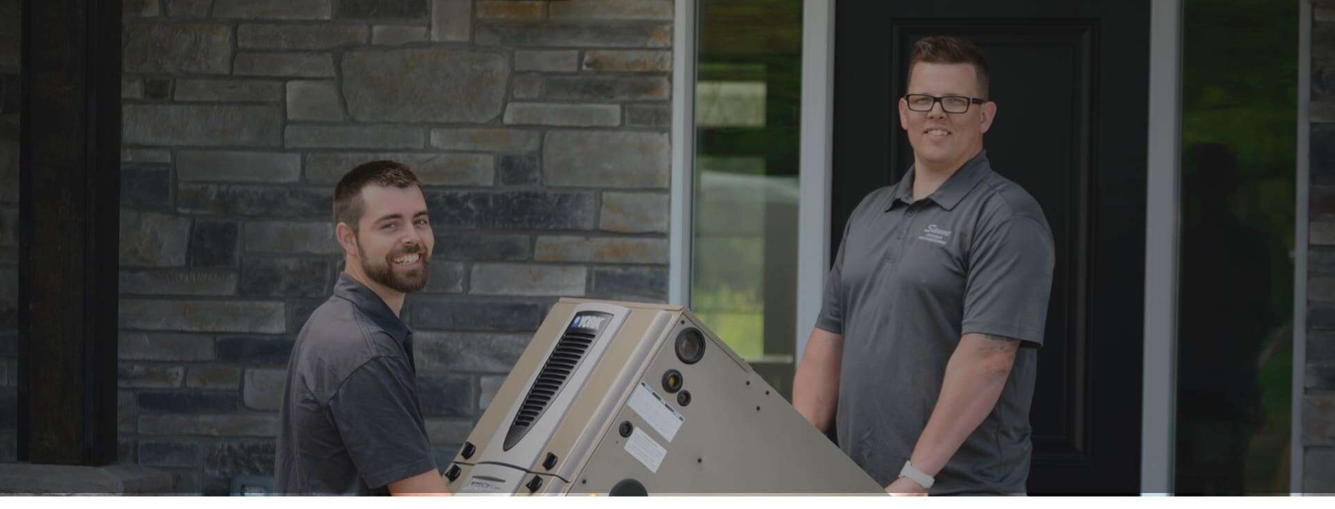 Two men carrying a large piece of equipment.